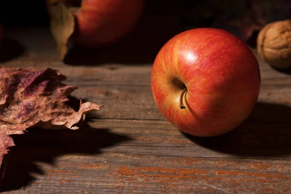 Äpfel und buntes Laub fallen auf alte rustikale Holzbretter. Herbst. Schöne Ernte Herbst Konzept. Herbstzusammensetzung — Stockfoto