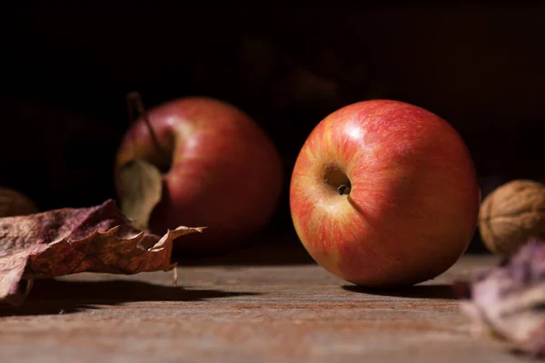 Äpfel und buntes Laub fallen auf alte rustikale Holzbretter. Herbst. Schöne Ernte Herbst Konzept. Herbstzusammensetzung — Stockfoto