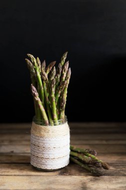 Ahşap arka planda taze yeşil organik kuşkonmaz. Sağlıklı gıda, diyet ve detoks ürünü, bir kalsiyum ve fosfor kaynağı.