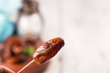 Beyaz arka planda terracotta kasesinde çiğ ve kuru hurma. Sağlıklı beslenmeye organik tatlılar. Ramazan Kareem