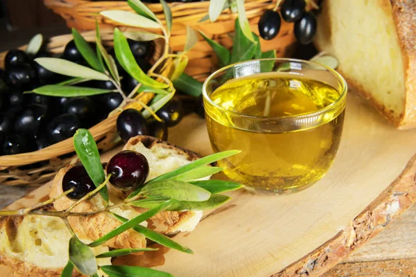 Közelről egy üveg tál olívaolajat kenyérrel és olívabogyóval. egészséges zsírok — Stock Fotó