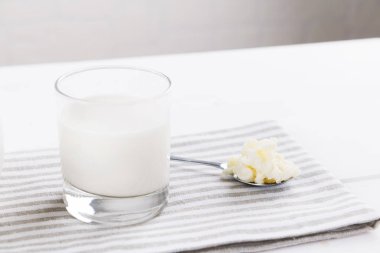 Beyaz arka planda kefir taneleri olan ev yapımı mayalanmış içecek kefir, doğal mayalanmış gıda ve bağırsak sağlığı kavramı