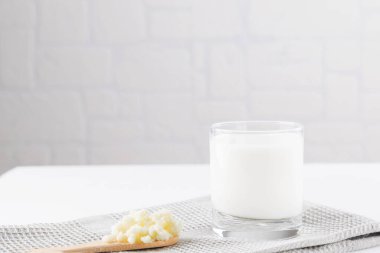 Beyaz arka planda kefir taneleri olan ev yapımı mayalanmış içecek kefir, doğal mayalanmış gıda ve bağırsak sağlığı kavramı