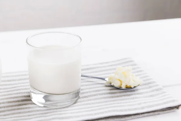 Kéfir casero de la bebida fermentada con los granos del kéfir en un tazón sobre un fondo blanco, concepto de alimento fermentado natural y salud intestinal —  Fotos de Stock