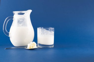 Doğal mayalanmış gıda ve bağırsak sağlığı kavramı, mavi arka planda kefir graiunları olan ev yapımı mayalanmış içecek kefir.