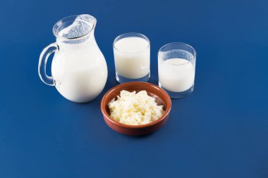 Doğal mayalanmış gıda ve bağırsak sağlığı kavramı, mavi arka planda kefir graiunları olan ev yapımı mayalanmış içecek kefir.