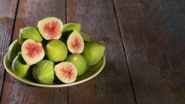 Yeşil yapraklı olgun yeşil incirler. Puglia, İtalya 'da yapılan ahşap bir arka planda sağlıklı Akdeniz incir meyvesi.