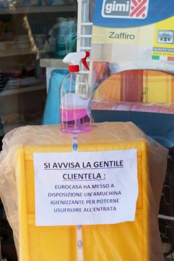 Avetrana, İtalya, Marth, 13, 2020. İçeri girmeden önce elleri sterilize etmek için bir dükkanın önünde el dezenfektanı. Kostümcülere dezenfektan kullanmalarını tavsiye eden İtalyan yazıtları. Covid-19 pandemisi sırasında alışveriş.