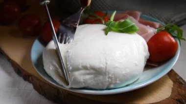 Puglia 'nın büyük mozarella peynirini blu tabakta kesen eller, İtalya' da yapılan yiyecekler, sade anahtar, yakın çekim, yavaş çekim