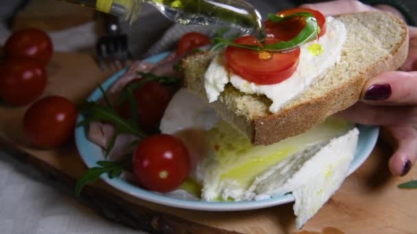 Olijfolie Giet Een Stuk Verse Italiaanse Sandwich Met Tomaten Arugula — Stockvideo
