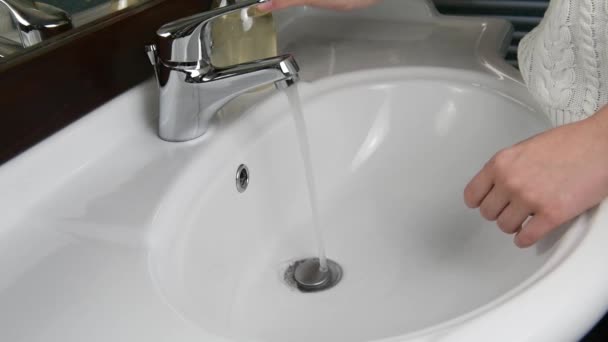 Handen van een mooie vrouw wassen hun handen in een gootsteen met schuim om de huid te wassen en water stroomt door de handen. Concept van gezondheid, reinigen en voorkomen dat ziektekiemen in contact komen met handen en schoonheid — Stockvideo