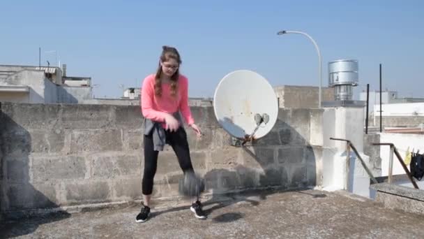 Σπίτι απομονωμένο. Νεαρό κορίτσι κάνει σπορ στην οροφή του σπιτιού της κατά τη διάρκεια της καραντίνας. Εκπαίδευση γυμναστικής σε αθλητικά είδη. Έννοια του αθλητισμού και της υγείας. Καραντίνα άθλημα στο σπίτι — Αρχείο Βίντεο