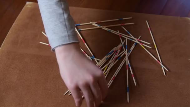 The player picks up some Mikado sticks on a floor — Stock Video