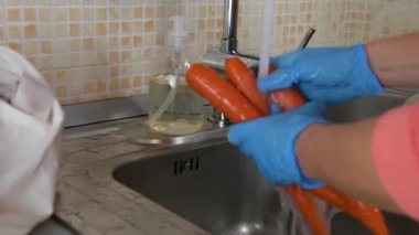 Tıbbi eldiven takan kadın eli kapalı Coronavirus salgını sırasında havuç yıkıyor. Kendini Cvid-19 'dan korumak için. Karantina karantinasında kendini tecrit