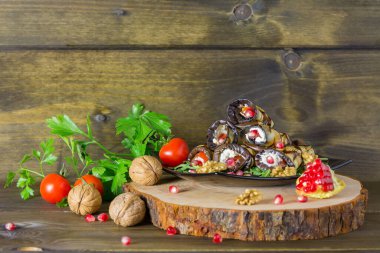 Fındıklı ızgara patlıcan ruloları, sarımsak ve otlar ve nar tohumları, ahşap arka planda Gürcü mutfağı ve fotokopi alanı