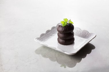 Çikolatada beyaz marşmelov ve gri arka planda nane yaprağı, Rus tatlısı.