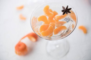 Mandalinalı Noel alkollü kokteyli, votka ve yıldız anason, hava kabarcıklı atmosferik yeni yıl fotoğrafı, üst manzara, kapat