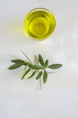 Apulia, İtalya 'da üretilen beyaz masa üzerinde bir kase ekstra saf zeytinyağı, kopya alanı, üst görünüm, dikey