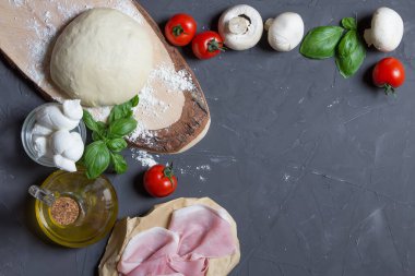 Gri tahtada çiğ pizza malzemeleri ve ortasında fotokopi alanı var. Resminizi ya da yazınızı ortaya koyabilirsiniz, hamur, domates, mantar, fesleğen, zeytinyağı, jambon, prosciutto