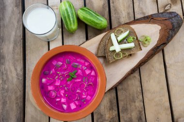 Soğuk yaz kırmızı pancar fermente çorba kefir, salatalık, kırmızı pancar, yeşil soğan, ahşap arka planda, üst görünüm