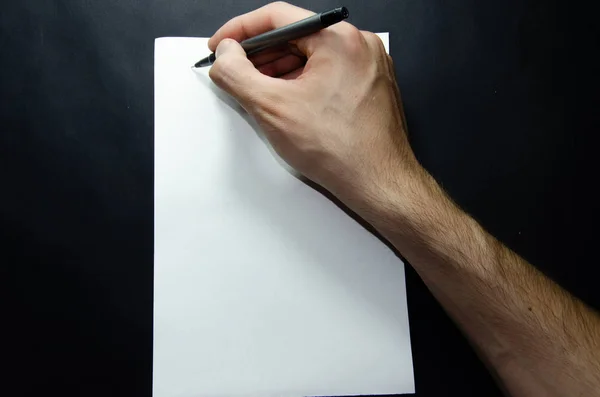 Erkek sol ve sağ el siyah arka planda beyaz bir kağıt üzerinde bir kalem tutuyor. Sayfa başına ögeler, Spor ve Fitnec — Stok fotoğraf