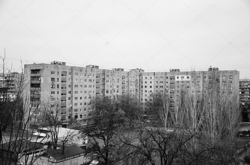Multi-storey panel house, old. Houses of the USSR, roof, stairs, communications. Black and white vintage photo.