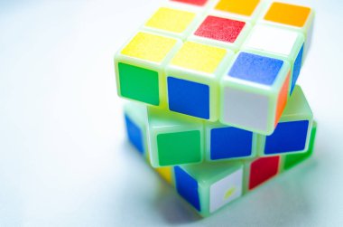 Beyaz arka planda ve ellerinde Rubik küpü
