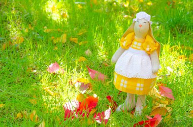 El yapımı oyuncak tavşan. Tavşan hanım, bunu doğal malzemelerden kendin yap. Elbise ve şapka giymiş oyuncak tavşan. Dekor makrosu.