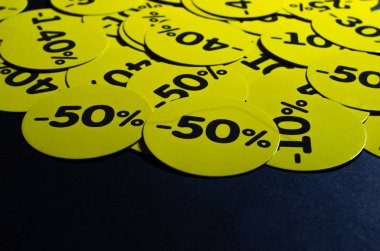 İndirimli sarı yuvarlak çıkartmalar% 10 ile% 50 arasında. Satılık. Siyah arka planda indirimler. Kara Cuma. Fiyat düştü. Posterler. Makro indirimler.