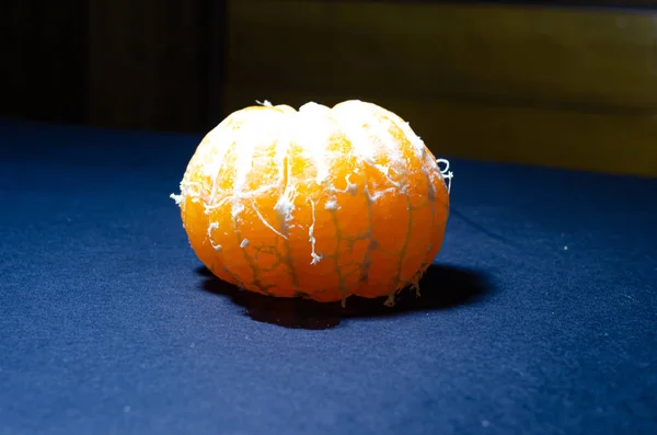 Bright mandarin on a black background. Tangerine skins on a dark background. Mandarin and its skins in macro. Slices, braces of mandarin. Citrus fruits in macro. — Stock Photo, Image