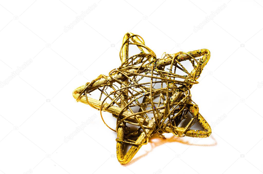 Do-it-yourself gold star made of wire to decorate a Christmas tree, for Christmas. A toy on a white background Macro