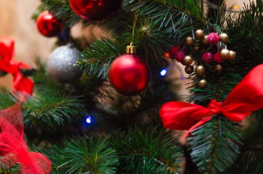Noel ağacı süslemesi. Toplar, ağaçtaki yıldız çelenkleri. Yeni yıl ağacında kırmızı fiyonklar. Festival ağacı parlak oyuncaklarla süslenmiştir. Yeni yıl havası. Mutlu Noeller..