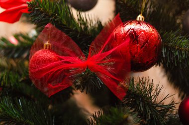 Noel ağacı süslemesi. Toplar, ağaçtaki yıldız çelenkleri. Yeni yıl ağacında kırmızı fiyonklar. Festival ağacı parlak oyuncaklarla süslenmiştir. Yeni yıl havası. Mutlu Noeller..