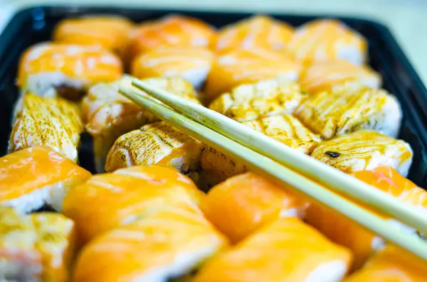 Fresh salmon philadelphia rolls. Smoked salmon rolls. Set of rolls on the board, table. One piece of roll. Food delivery, sushi. A lot of rolls. Sticks for rolls. Macro. — Stock Photo, Image