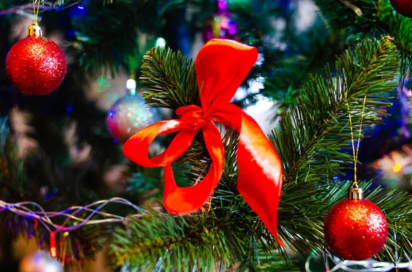 Noel ağacı süslemesi. Toplar, ağaçtaki yıldız çelenkleri. Yeni yıl ağacında kırmızı fiyonklar. Festival ağacı parlak oyuncaklarla süslenmiştir. Yeni yıl havası. Mutlu Noeller..