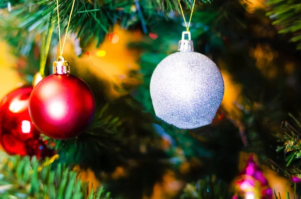 Noel ağacı süslemesi. Toplar, ağaçtaki yıldız çelenkleri. Yeni yıl ağacında kırmızı fiyonklar. Festival ağacı parlak oyuncaklarla süslenmiştir. Yeni yıl havası. Mutlu Noeller.. — Stok fotoğraf