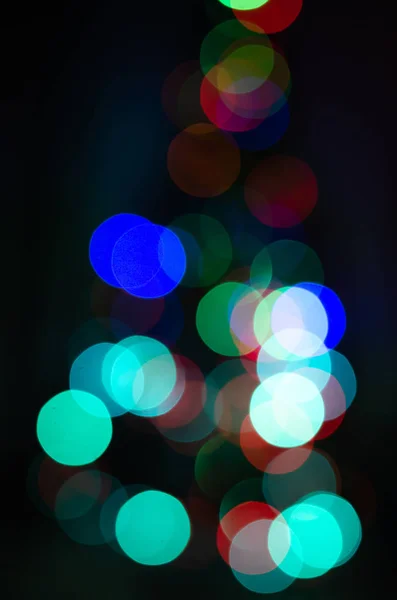 Arbre de Noël déconcentré. Le bokeh est rond, sous la forme d'un arbre de Noël. Guirlande de Noël hors foyer . — Photo