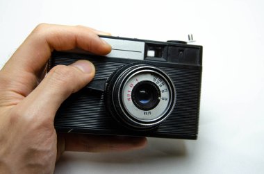 Eski film kamerası. Beyaz arka planda nadir bulunan bir kamera. İlham perilerinin elinde bir kamera. Sovyet fotoğraf ekipmanları. Makro kamera, lens, içerisi, detaylar. 