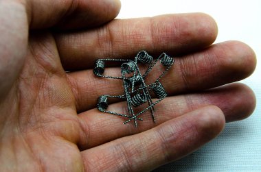 Beyaz arka planda ve elde elektronik sigaralar için bobinler 