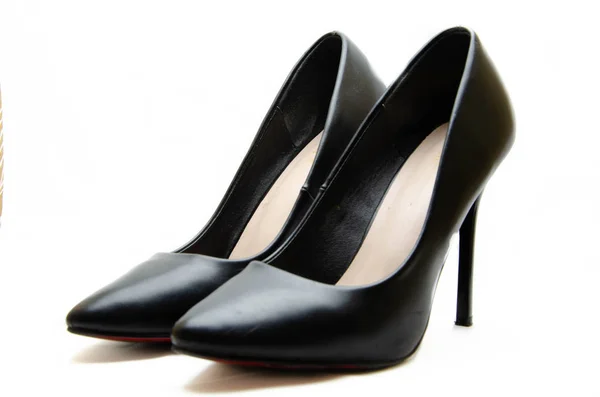 Женская обувь в черном с красной подошвой на белом фоне. Туфли на праздник, офисные туфли. Высококаблуковые туфли, шпильки. Женская обувь крупным планом . — стоковое фото