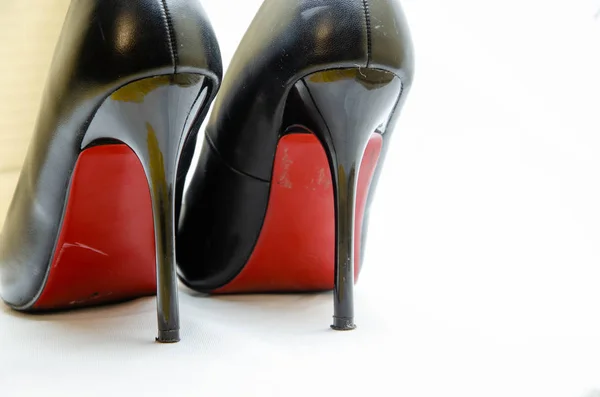Damesko i svart med rød såle på hvit bakgrunn. Sko til høytiden, kontorsko. Høye hæler, stiletthæler. Nærbilde av kvinnesko . – stockfoto