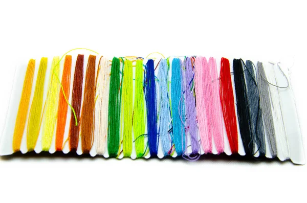 Fios multicoloridos para bordados e bordados em um fundo branco . — Fotografia de Stock