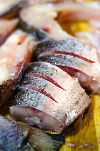 Piezas, pescado crudo picado en una tabla de madera. Pescado en macro. Pescado en la sal. Gusanos en los peces. Peligro de intoxicación por pescado . —  Fotos de Stock