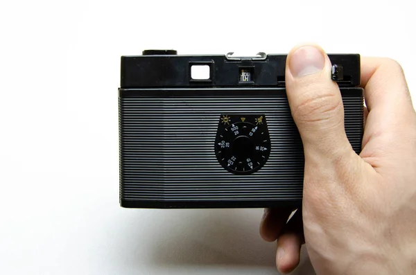 Old film camera. Rarity camera on a white background. A camera in muse hands, cocking. Soviet photographic equipment. The camera in macro, lens, inside, details