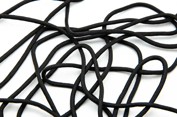 İp Paracord. Dokuma ve turizm için paraşüt. Güvenlik halatı. Beyaz arka planda ve ellerinde siyah taktik paraşüt. 
