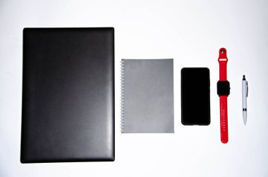 Laptop, akıllı telefon, akıllı saat ve beyaz ve siyah arkaplanlı kalemli defter. Kompozisyon. Farklı yönlerden bak. Kopyala yapıştır, düz kabuk. Çalışmak ve tasarlamak için araçlar. Serbest İşyeri