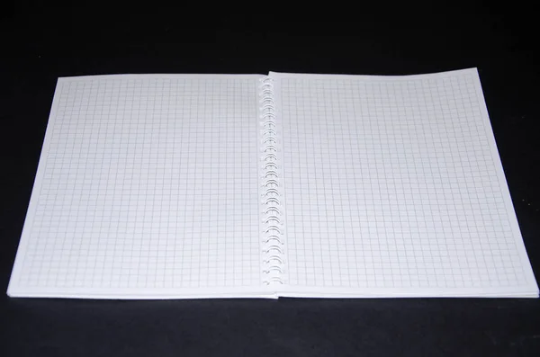 Caderno cinza para notas e uma caneta branca sobre um fundo preto. Bloco de notas em estado fechado e aberto, expandido. Bloco de notas para escrever ideias, plano, tarefas. Um diário. Vista de cima. Bloco de notas fixado por espiral — Fotografia de Stock