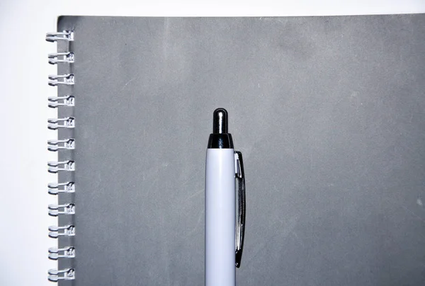 Gray notebook with white pen on a white background. Notepad for notes, ideas, tasks. A diary — Stock Photo, Image