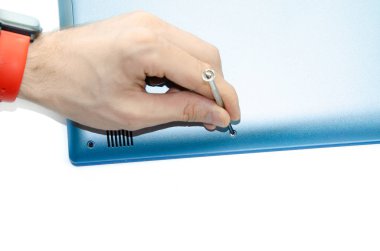 Erkek eller bir aleti, bir tornavidayı tutar ve dizüstü bilgisayardan vidayı çıkarır. Bilgisayarı söküyorum. Servis bakımı. Lens parlamasını yükselt