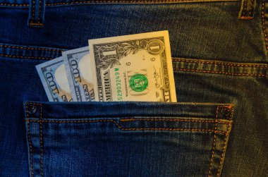 Kot pantolonun cebinde Amerikan banknotları. 100 dolarlık banknotlar halinde bir not, arkadan sarkıyor, en önde gelen pantolon cebi. Para cebimden çıkar. Fişek etkisi. Farklı açılardan görüntüle